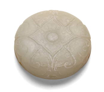 White Jade Circular Cover: D: 4.5 cm, H: 1 cmA circular white jade cover, well carved with stylised scrollwork and a central medallion, the translucent stone with soft polish, Qing dynasty.