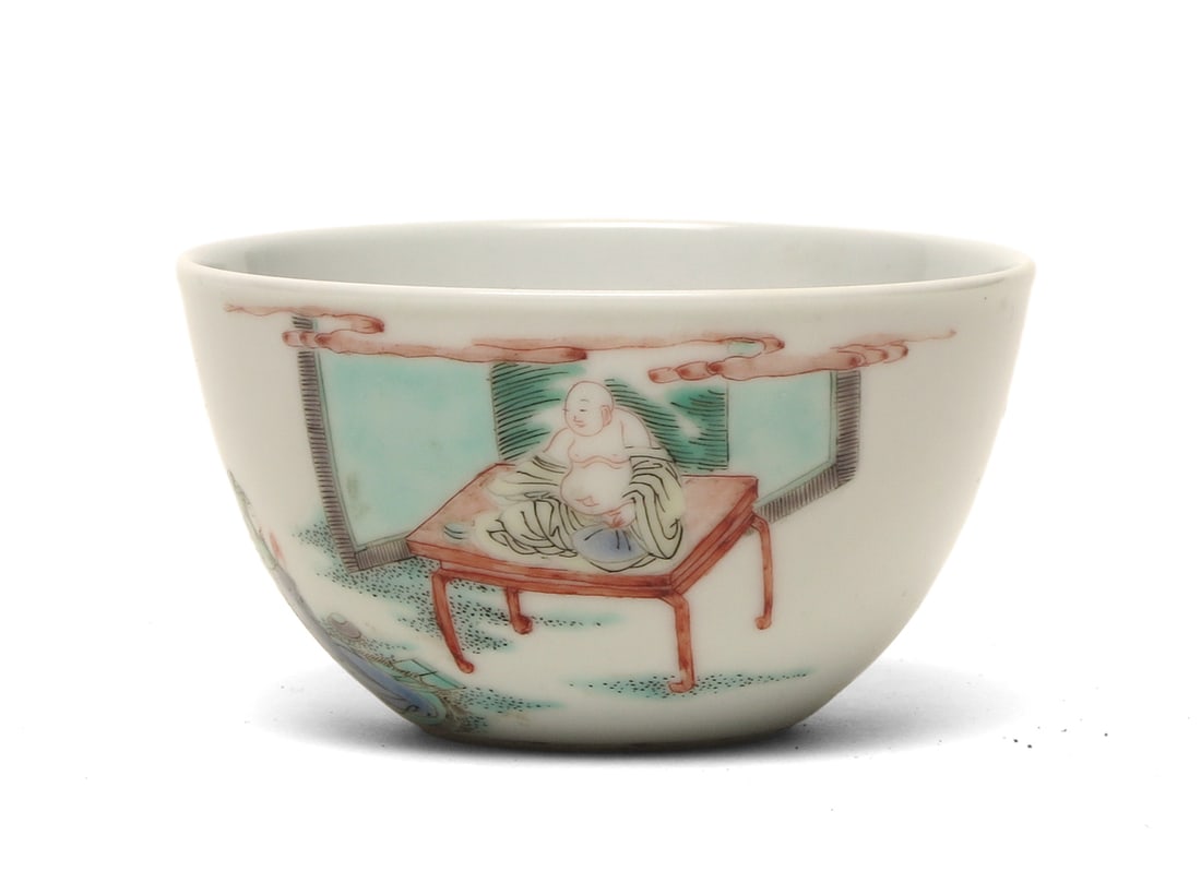 Famille Rose Porcelain Bowl With Budai Figure: D: 8.5 cm, H: 4.6 cmA finely enamelled famille rose porcelain bowl, the exterior delicately painted with the figure of Budai seated on a low table, depicted with a smiling expression and draped robes 