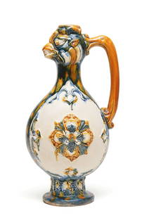 Sancai-Glazed Dragon-Head Ewer: H: 15 cmA Tang-style sancai-glazed pottery ewer with a spout in the form of a dragon's head, decorated with floral medallions and vibrant green, amber, and cream glazes.