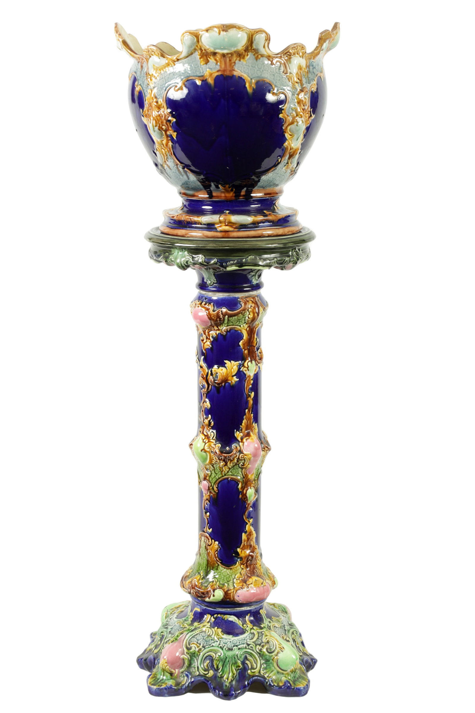 A Majolica Jardiniere: Dimensions: Height 126 cm. Description: A majolica jardinière on pedestal, the tall stem rising to a flared planter with richly coloured glaze. Blue, purple and green tones run across the moulded
