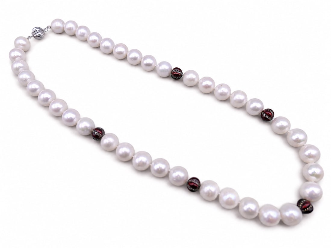An 18 ct white gold diamond section and pearl necklace: Dimensions: Length 46 cm. Description: An 18 ct white gold diamond-set and pearl necklace. The strand of softly lustrous pearls is punctuated by darker bead accents and a diamond-set white-gold sectio