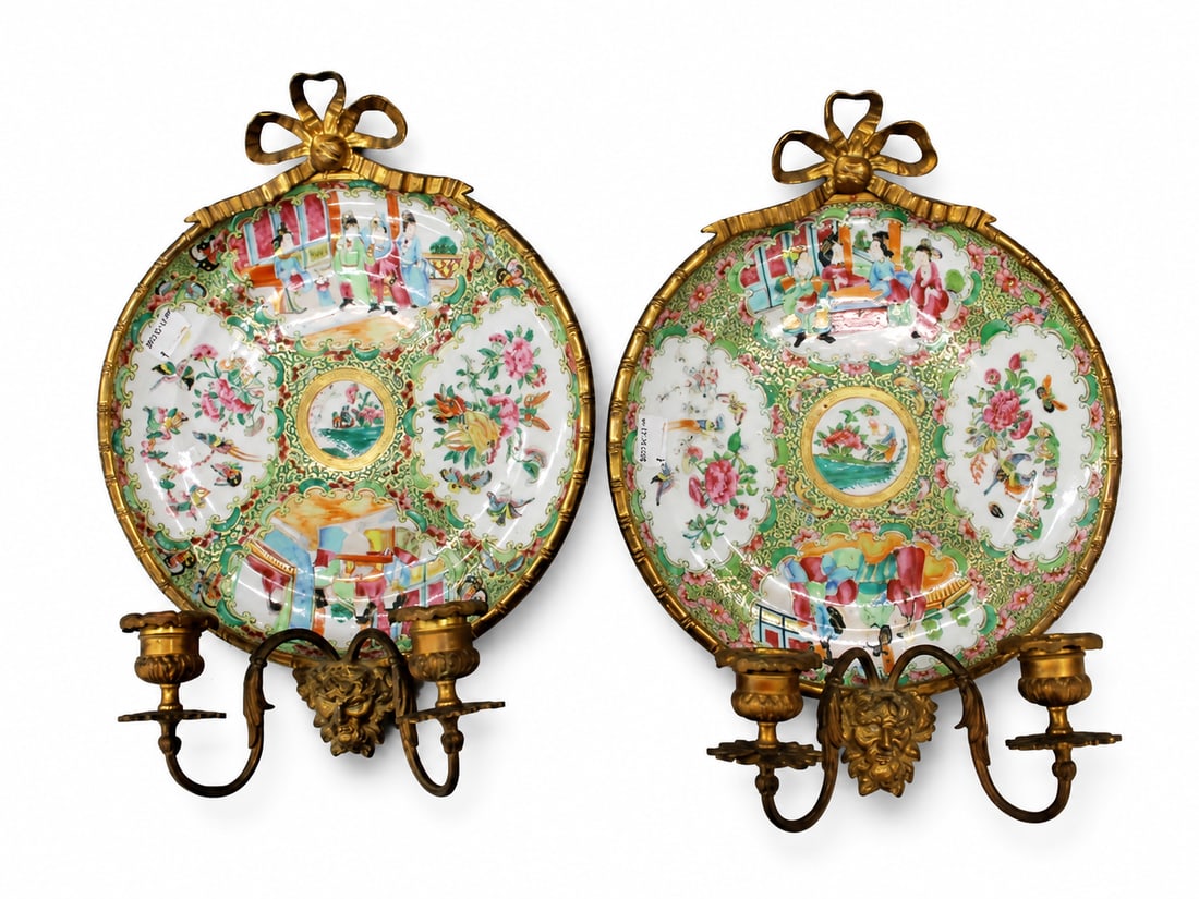 A pair of 19th century ormolu mounted Canton famille rose plates: Dimensions: Width 25 cm. Description: A pair of 19th-century ormolu-mounted Canton famille rose plates, each adapted as a twin-branch wall light. The porcelain plates are densely enamelled with