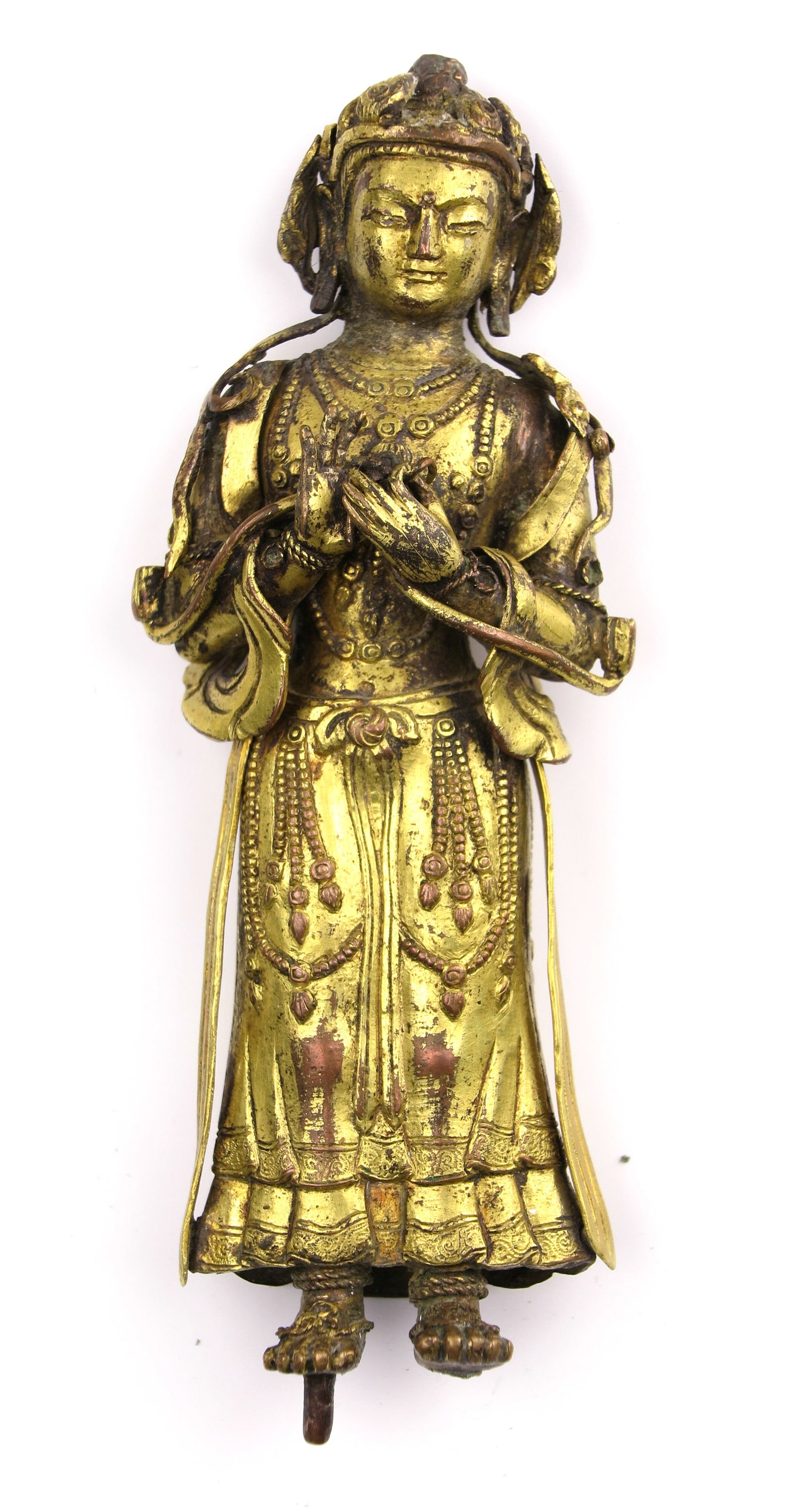 A small gilt-metal standing figure: Dimensions: Length 11.6 cm. Description: A small gilt-metal standing figure, modelled frontally in long robes with carefully indicated facial features and costume detail. The worn gilding catches