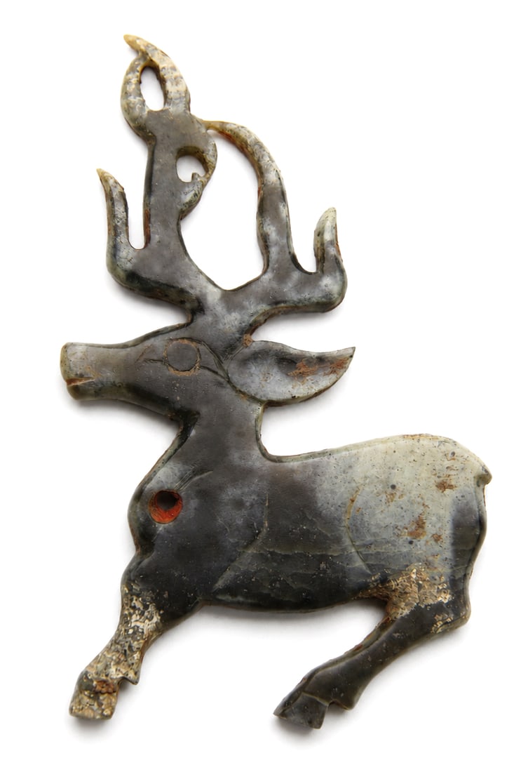 An archaic jade figure of a deer: Dimensions: Length 7.2 cm. Description: An archaic jade figure of a deer. A rare and finely carved archaic jade 'deer' pendant, Shang or Western Zhou Dynasty. The flattened jade is skillfully carved a