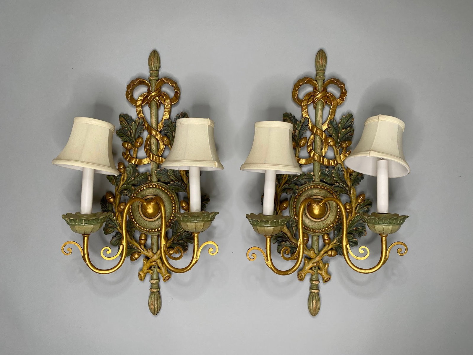 Pair Of Italian Baroque Style Wood Carved And Paint Decorated Two Light Sconces, Circa 1960: with acorn and ribbon hand carved decoration H: 24 3/4, w: 12 3/4, d: 7 1/2 inches