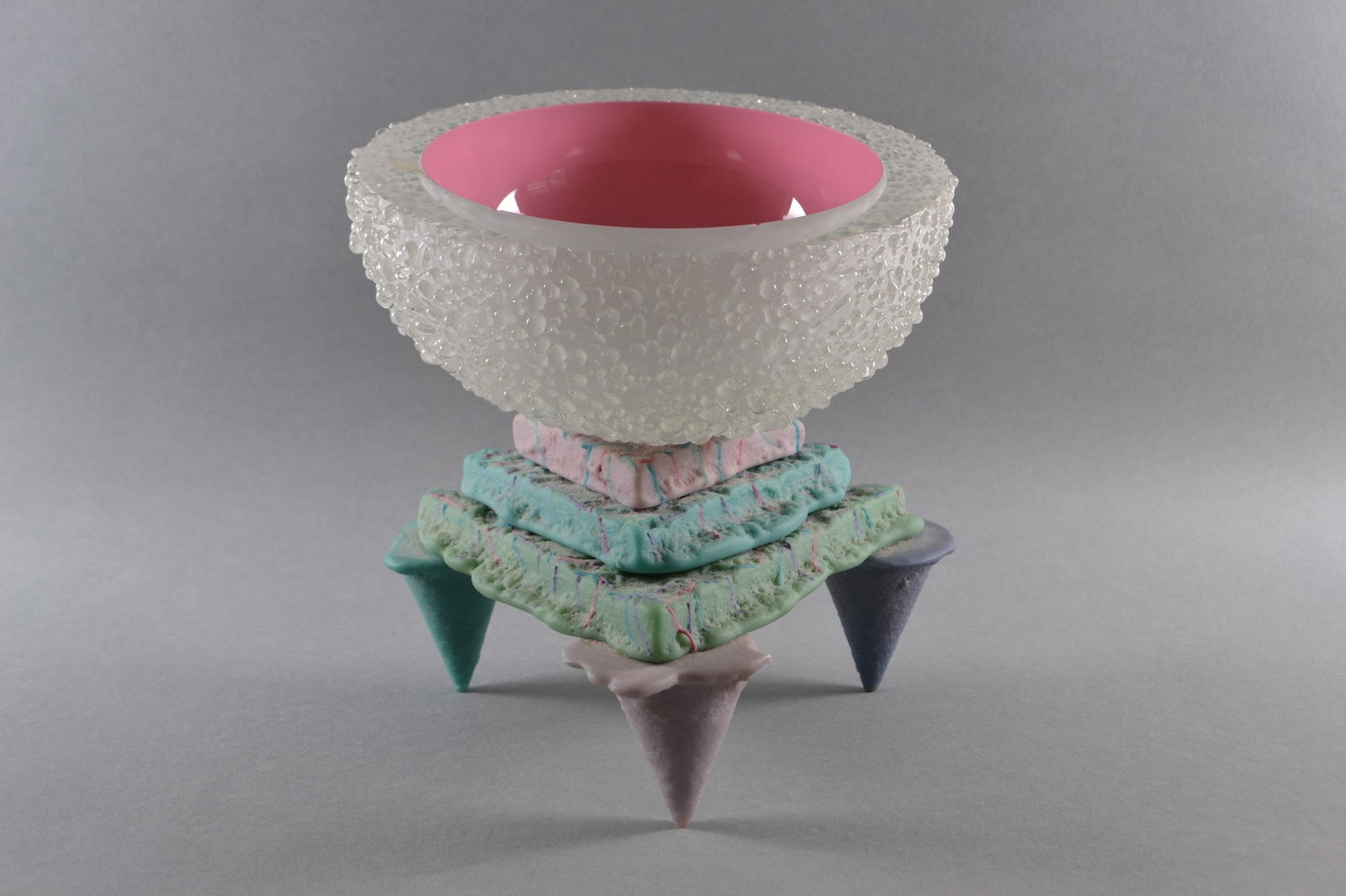 Molly Stone (American)Postmodern Memphis Style Pink Teal Purple Studio Art Glass Sculpture, 1988: Urchin form bowl on tripod stand signed and dated on underside: M Stone 1988CONDITION: 2 chips to the interior rim of the bowl, H: 9 1/4, w: 8 1/2, d: 7 3/8 inches