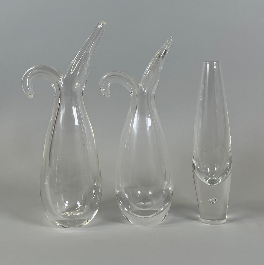 Steuben Sheared Rim And Teardrop Bud Vases (3), C 1950s: Sheared Rim larger H: 10 1/4 x w: 5 3/4 x d: 2 inches Sheared Rim smaller H: 9 3/4 x w: 5 x d: 2 inches Teardrop H: 8 1/4 x w: 1 3/8 inches