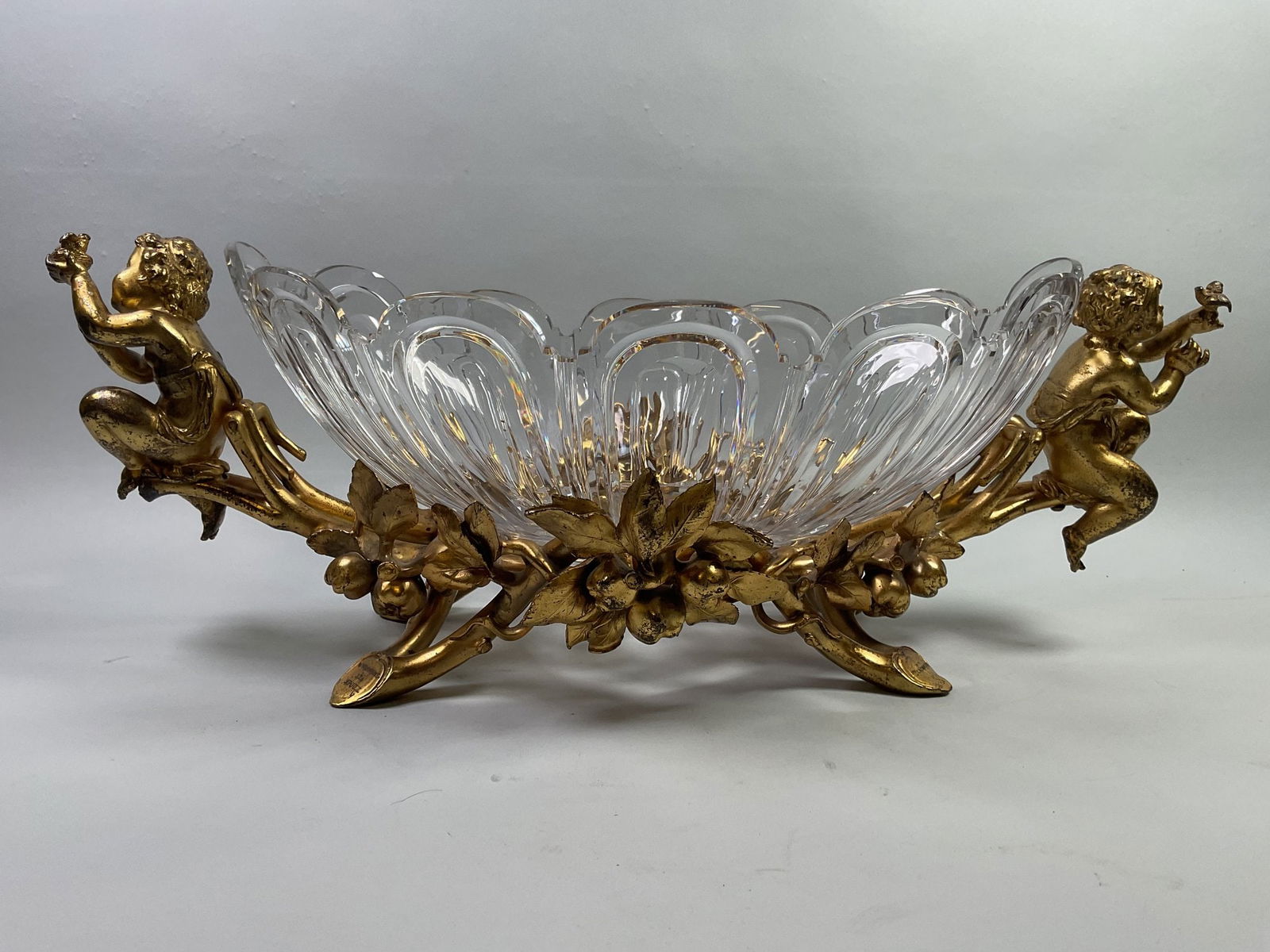 Christofle (France) Gilt Bronze And Glass Figural Centerpiece, C. 1862: stamped CHRISTOFLE to underside of base Base - H: 7 3/4 x W: 21 1/2 inches Glass - H: 5 1/2 x W: 15 1/2 inches