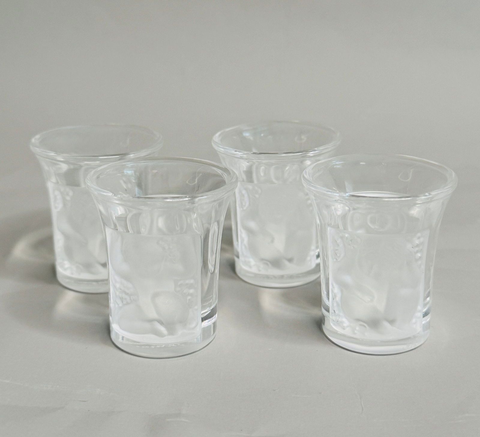 Lalique Enfants Crystal Shot Glasses (4): Stamped Lalique France on underside, H: 1 3/4 x dia.: 1 1/2 inches. CONDITION: Excellent