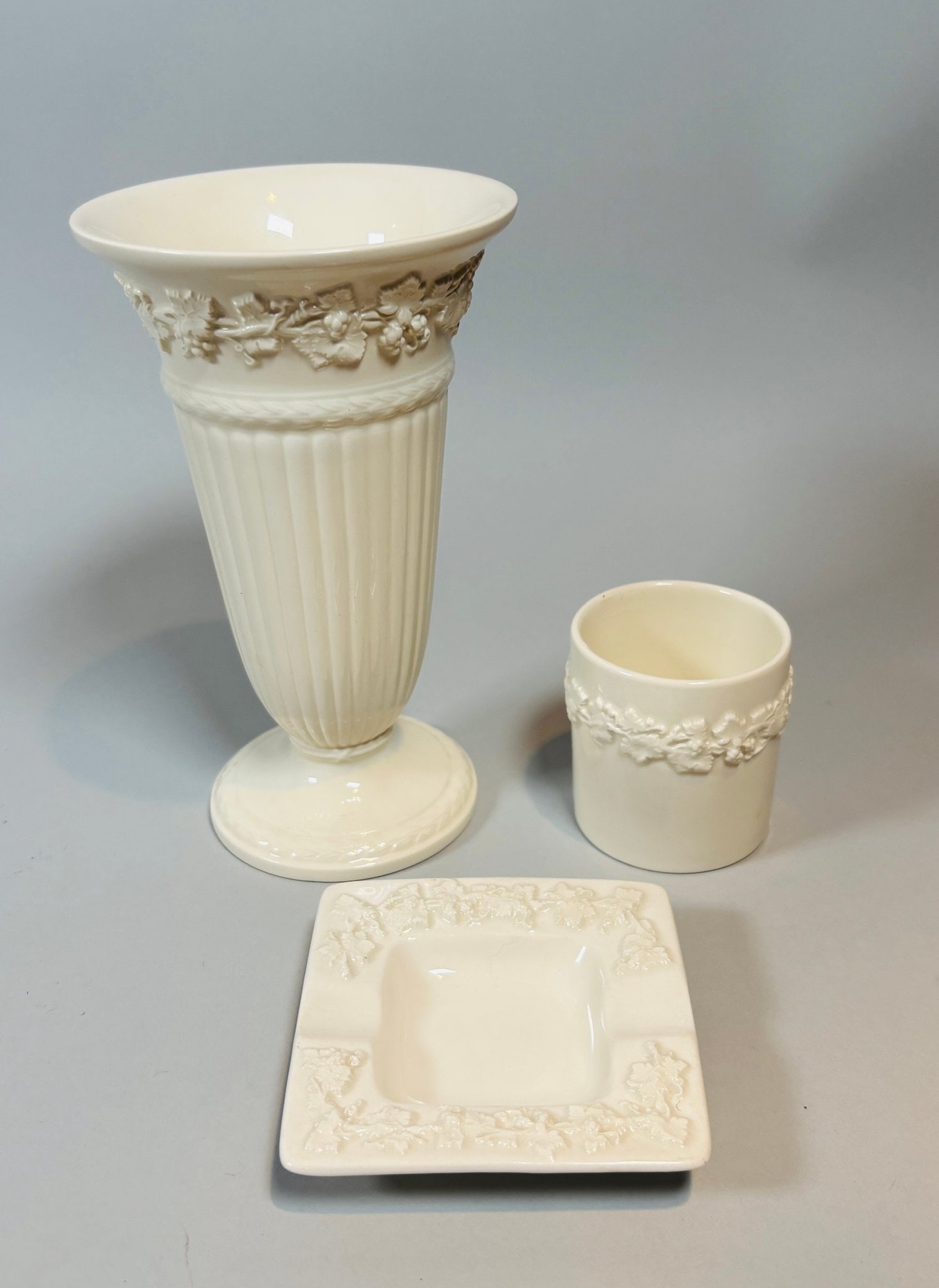 Wedgwood Queens Ware Grapevine Trumpet Vase, Cup, And Ashtray (3): All marked Wedgwood on undersides Trumpet Vase: H: 6 3/4 x w: 4 x d: 4 inches Cup: H: 2 1/2 x w: 2 1/2 x 2 1/2 inches Ashtray: H: 3/4 x w: 3 1/2 x d: 3 1/2 inchesCONDITION: excellent