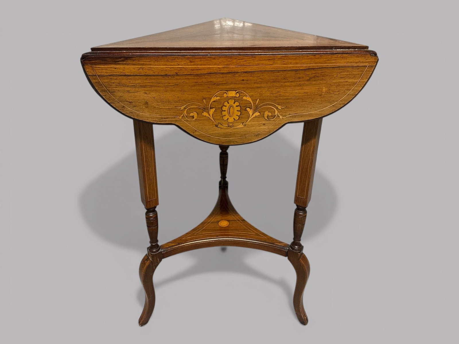 Edwardian Rosewood Triangular Drop Leaf Side Table, C. 1900: With marquetry inlays and a top which unfolds to create a curvilinear shaped surface each leaf having a trefoil shape h: 28 x dia: 22 inches (opened) w: 18 x d: 18 inches (folded)CONDITION: fading and