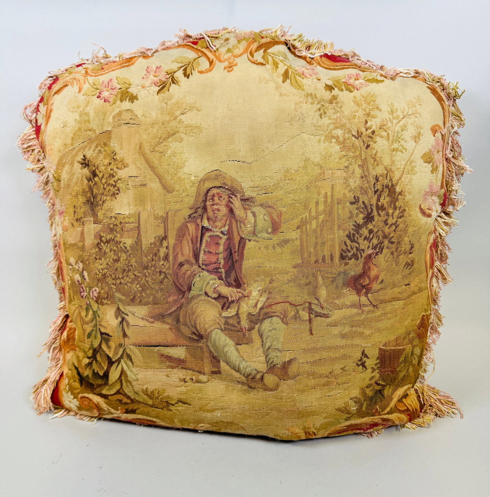 Antique Aubusson Tapestry Throw Pillow: Tapestry panel featuring a provincial scene silk damask backing and fringe trim h: 16 x w: 16 inches CONDITION: tapestry panel worn and has areas of repair and small tears