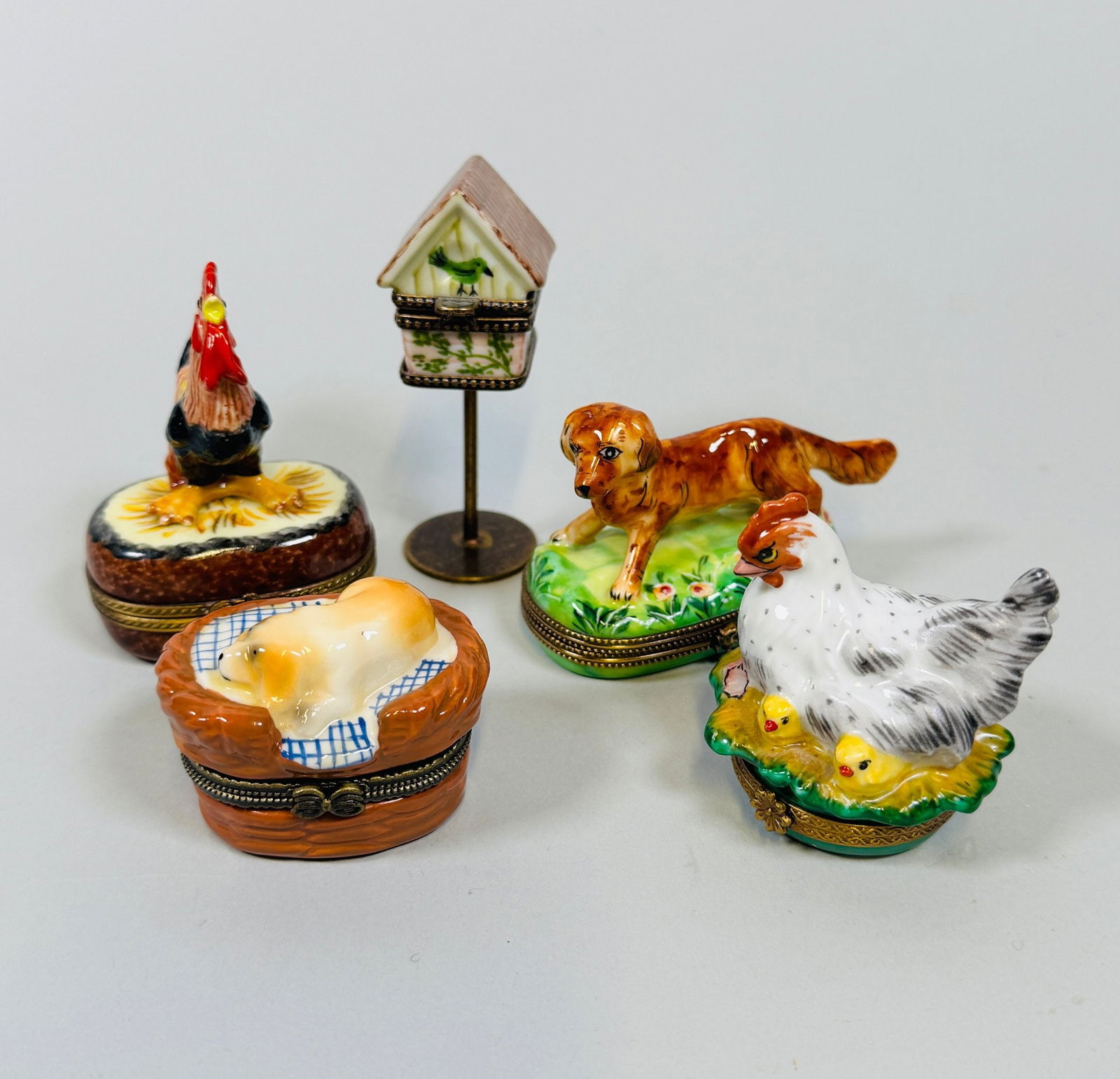 Limoges Hand Painted Porcelain Boxes (5): Irish Setter box marked Rochard Limoges; chicken rooster and birdhouse boxes marked peint main Limoges; dog in basket box is unmarkedBirdhouse h: 3 inches Irish Setter h: 2 x w: 3 x d: 1 inches