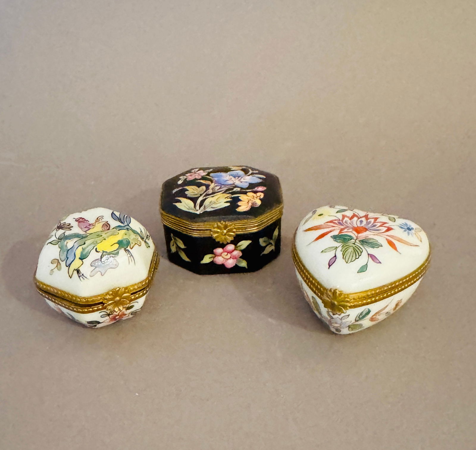 Two Tiffany & Co. Miniature Limoges Boxes Together With A Third Limoges Box (3): Two polychrome painted miniature Limoges covered boxes marked hand painted for Tiffany & Co. and Limoges France; one heart-shaped h: 1 1/2 x w: 2 x d: 2 inches; one hexagonal h: 1 1/2 x w: 2 x d: