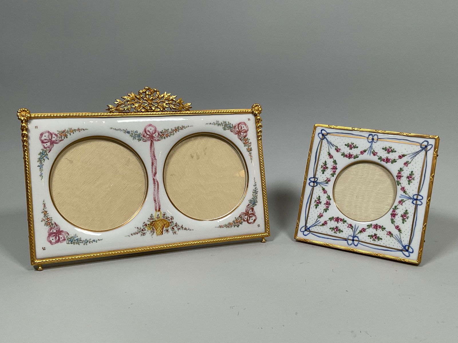 Empire Style Gilt Metal Mounted And Hand Painted Porcelain Picture Frames (2), 20th Century: Possibly Limoges both with Limoges style ribbon bow and floral motifs the double frame h: 7 1/2 x w: 10 3/4 inches (overall); dia: 4 inches (openings); the single frame h: 5 5/8 x w: 5 5/8 inches (ove