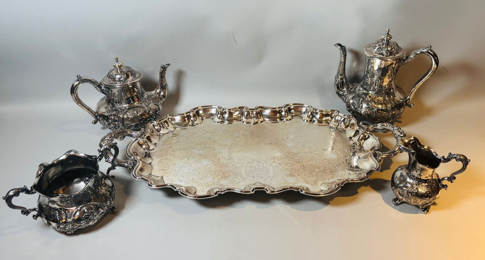 Silver Plate Tea Set With Orientalist Motifs And Associated Tray (5-piece): includes tray teapot coffee pot creamer and open sugar bowl; tray w: 25 x d: 13 inchesCONDITION: sugar bowl has broken foot teapot lid is broken at hinge