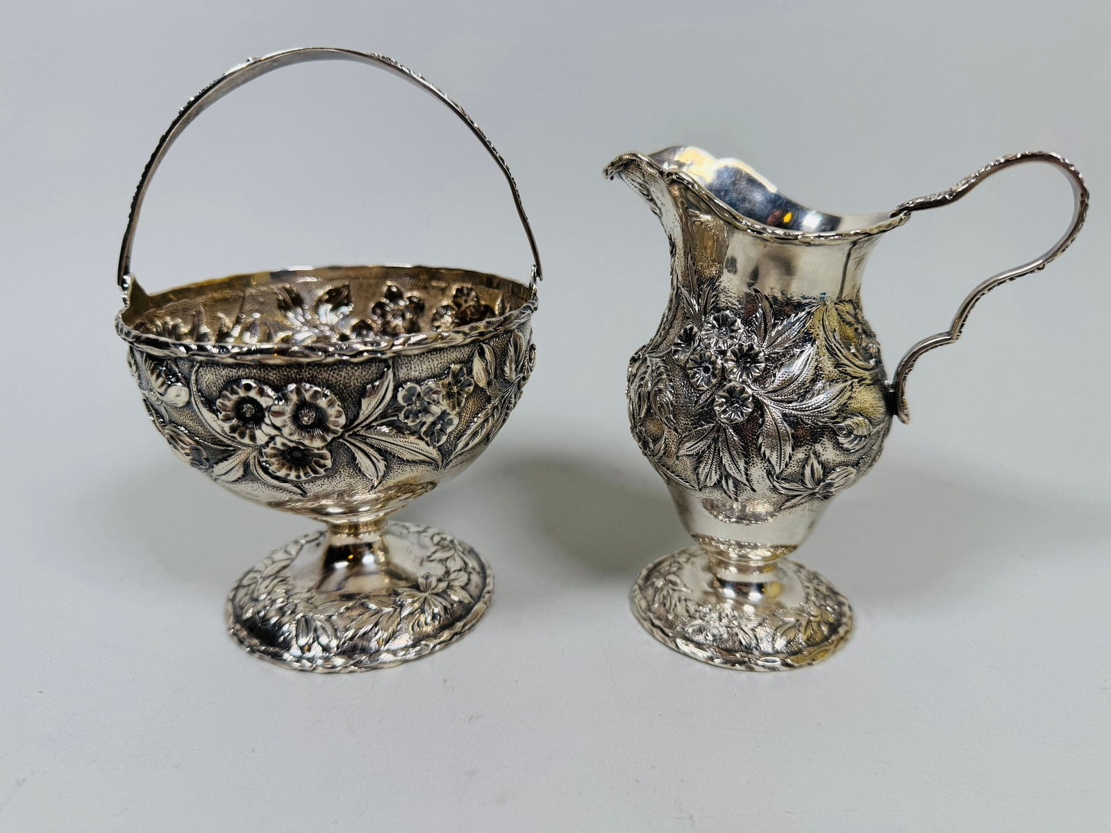 S. Kirk & Son, Baltimore, Sterling Silver Repousse Sugar Basket And Creamer, C. First Quarter 20th: Stamped under feet S Kirk & Son Co/925 urn-form basket with swing bale handle both monogrammed basket h: 6 inches (including handle) x dia: 4 inches creamer h: 5 inches OZT: 10.57