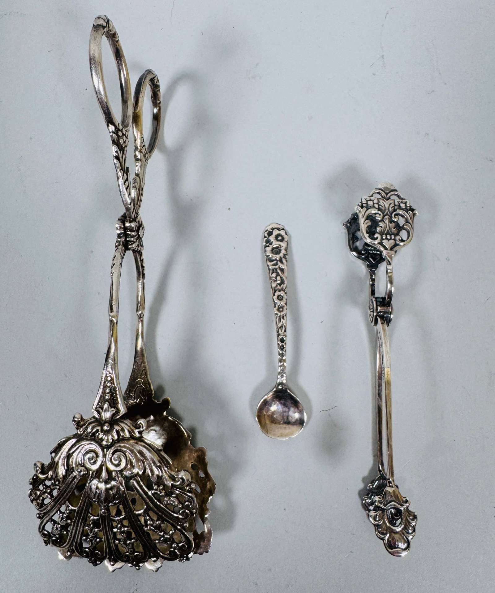 Group Of Sterling And .800 Silver Serving Utensils (3): including a salt spoon and two pairs of tongs OZT: 2.42