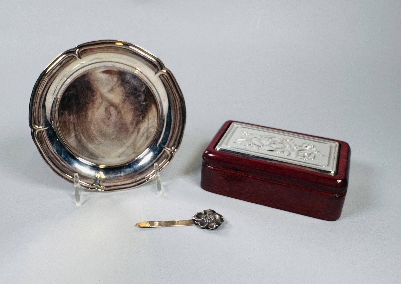 Collection Of Vintage Silver Desk Accessories, C. Mid-late 20th Century (3): Includes a small box with sterling silver inset top h: 1 1.2 x w: 4 1/2 x d: 3 inches; a letter opener 2 1/2 inches; a small silver plate trinket dish dia: 5 inches OZT: .13 (letter opener only)