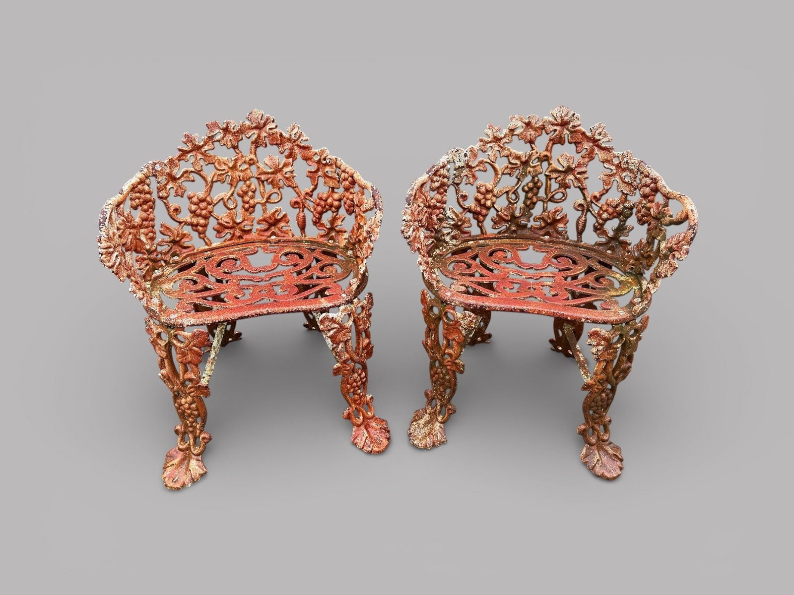 Pair Of White Antique Cast Iron Garden Chairs With Grapevine Motif (2): H: 27 x w: 21 x d: 17 inchesCONDITION: rusted overall