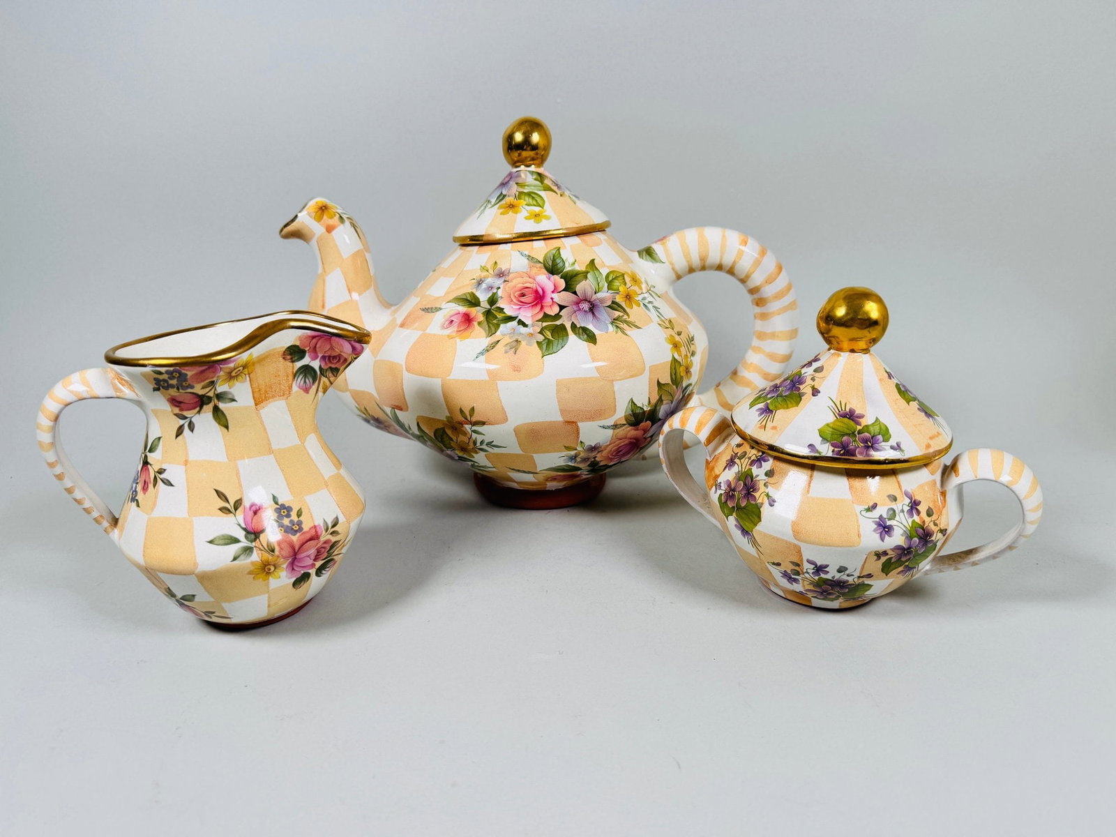 MacKenzie-Childs Stoneware Honeymoon Orange Marmalade Teapot, Creamer And Sugar Bowl In Morning: marked and dated underneath teapot h: 9 x: w: 11 x d: 8 inchescreamer h: 5 inchescovered sugar bowl h: 6 inchesCONDITION: excellent