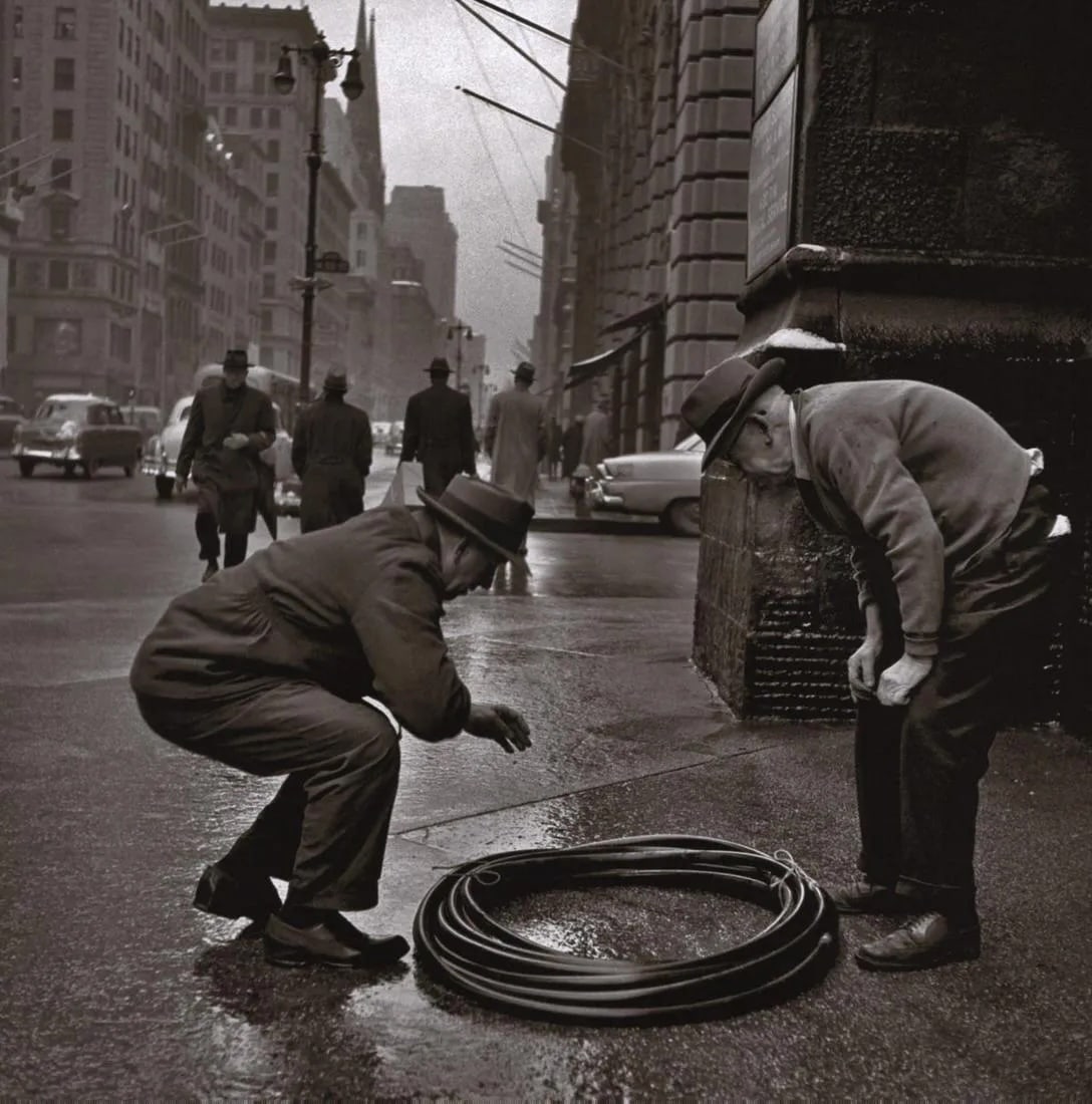 Vivian Maier - Men Looking at Hose: Men Looking at HosePhoto-litho, c. 2000'sDimensions: 9 x 9 inchesWork is mounted