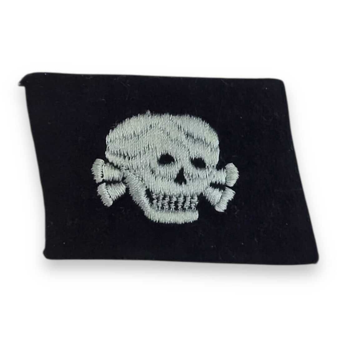 German WW2 Totenkopf EM Collar Tab - SS Enlisted Rank: This is an authentic German World War II Totenkopf (Death's Head) EM collar tab, worn by enlisted men (EM) of the SS-Totenkopfverbände, the SS units responsible for the administration of concentratio