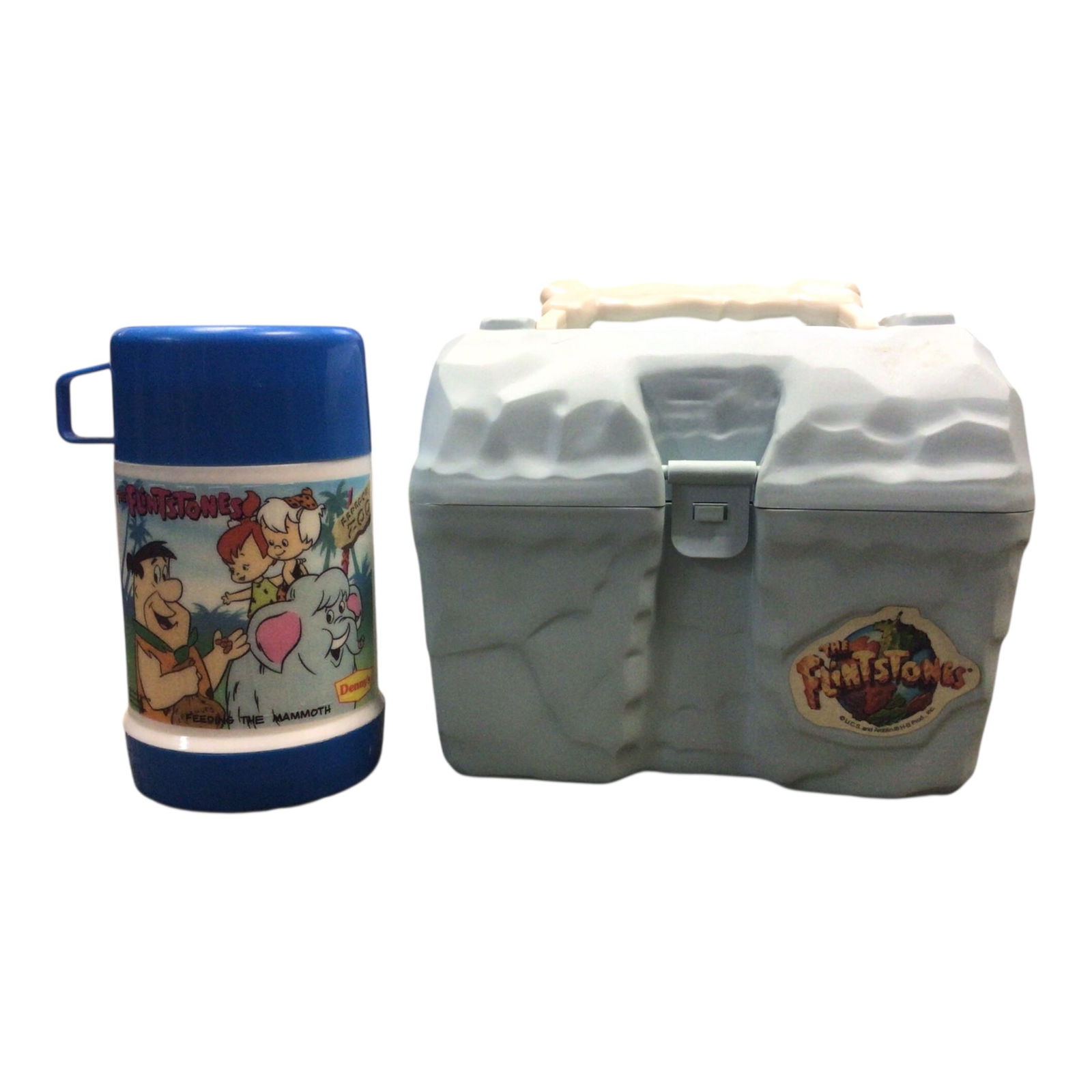 Vintage 1994 Flintstones Plastic Lunchbox & Thermos Set: Take a prehistoric trip down memory lane with this 1994 Flintstones lunchbox and thermos set, a fun and functional tribute to the classic cartoon. The plastic lunchbox mimics stone with a faux-rock ex