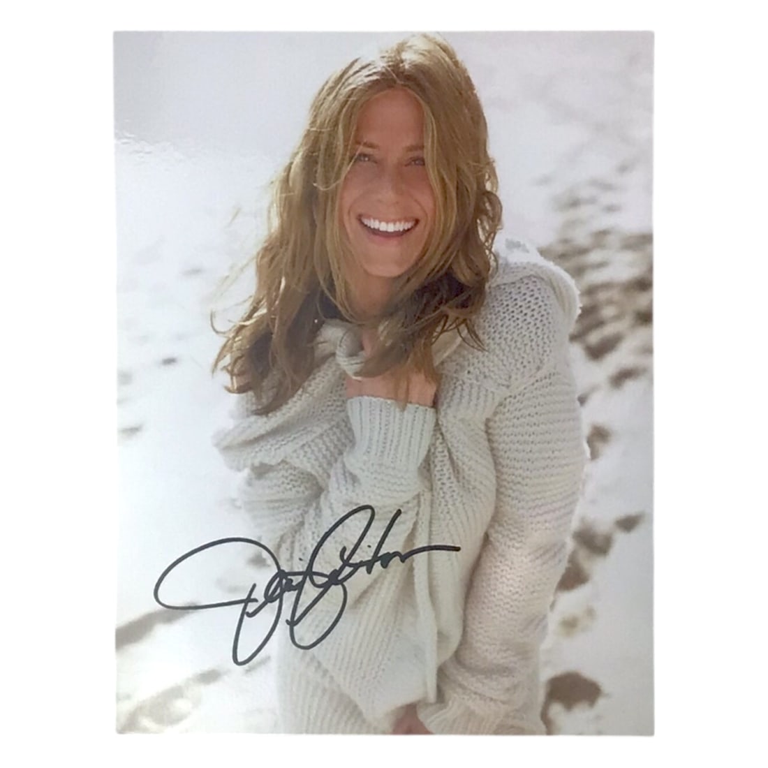 Jennifer Aniston Signed Photograph - Movie Star Memorabilia: Here is a warm and inviting signed photograph of Jennifer Aniston, showing the actress in a casual sweater with a radiant smile. The autograph, placed neatly in black ink, stands out clearly against t