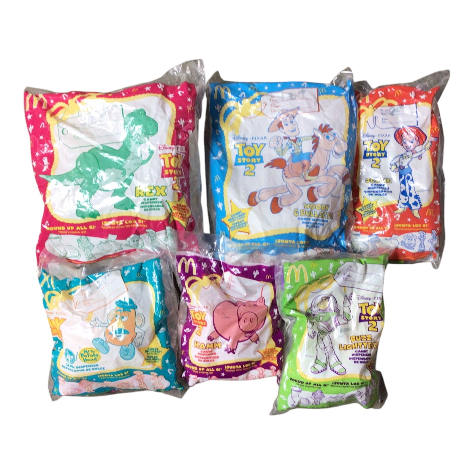 Complete 1999 McDonald's Toy Story 2 Candy Dispensers Set - All Sealed: Offered here is the full 1999 McDonald's Toy Story 2 candy dispenser set, featuring six fan-favorite characters: Rex, Woody & Bullseye, Buzz Lightyear, Jessie, Mr. Potato Head, and Hamm. Each dispense