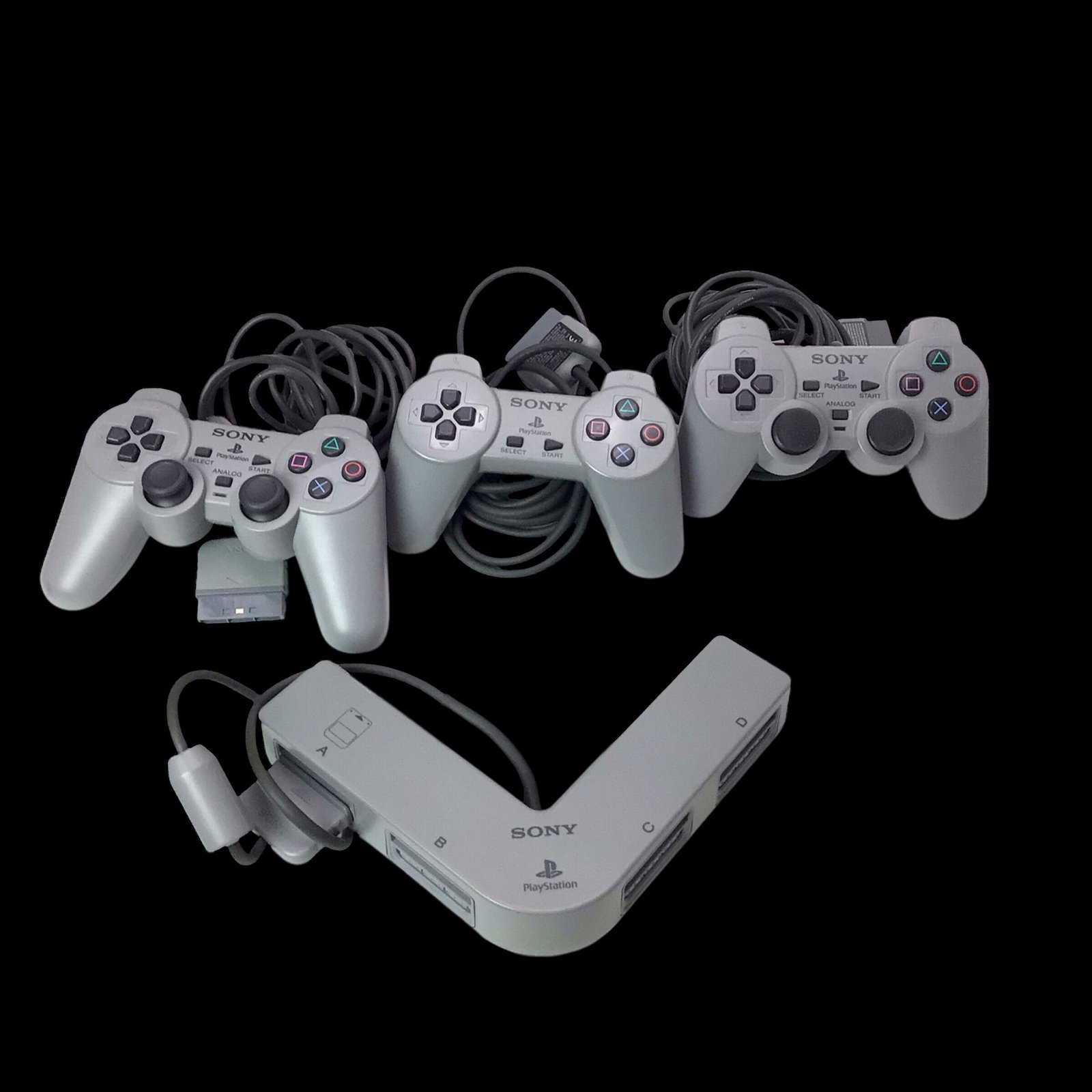 3 Sony PlayStation Controllers & Multitap Adapter: Lot of three original Sony PlayStation controllers accompanied by an official Multitap adapter, allowing up to four players to connect for multiplayer sessions. These peripherals remain pre-owned and 