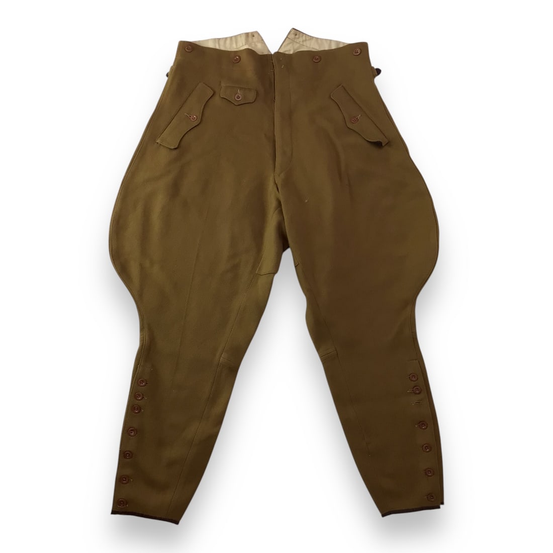German NSDAP Riding Breeches with Original Tag: This original pair of German WWII NSDAP riding breeches is constructed in a brownish-green wool fabric and retains its original factory tag with maker information and NSDAP markings. The trousers feat