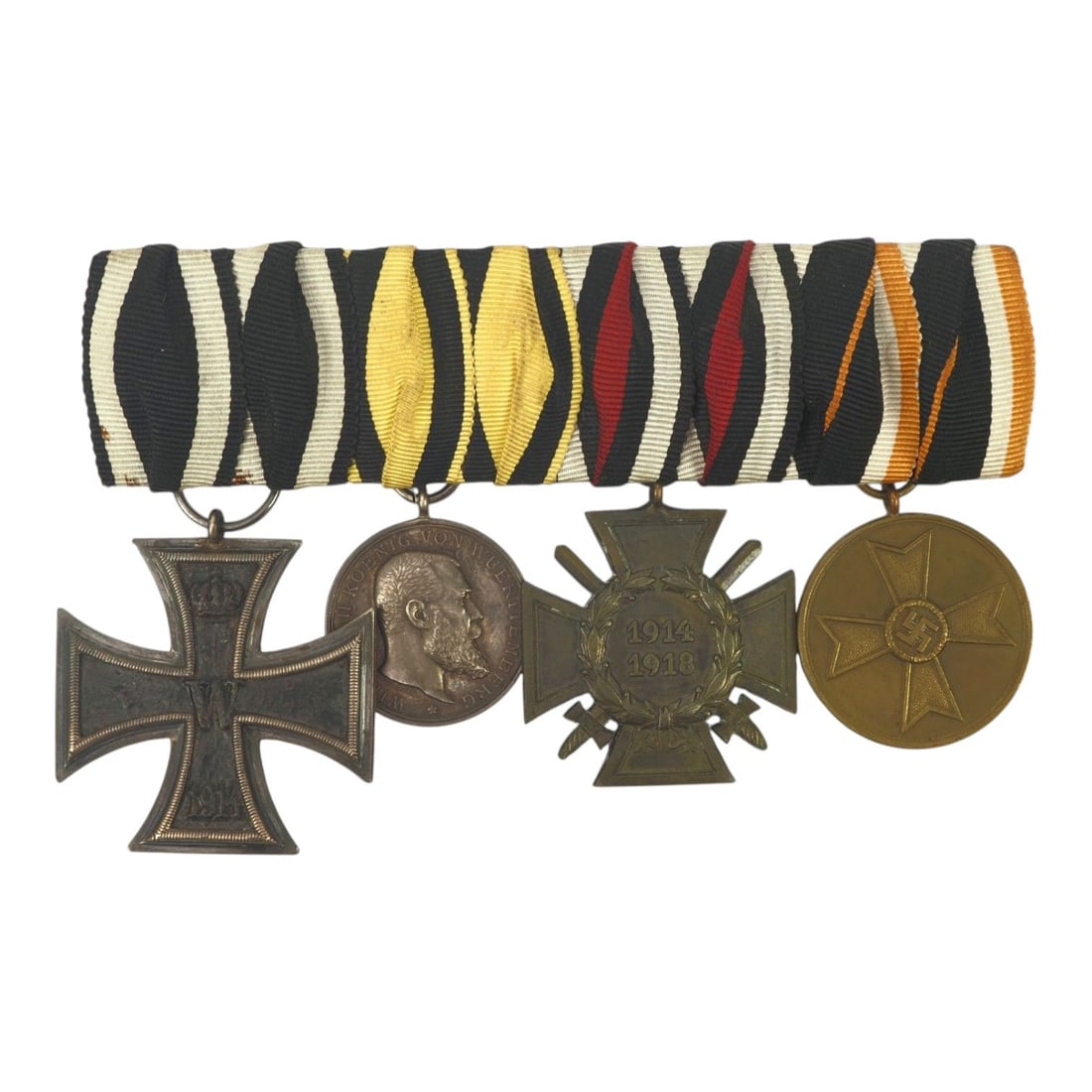 German WWI-WWII Four-Medal Uniform Dress Bar with Iron Cross & War Service Medal: This German WWI and WWII four-medal bar is a complete uniform dress and parade-mounted group retaining its original ribbons. The bar consists of a 1914 Iron Cross 2nd Class, a Baden-Württemberg Brave
