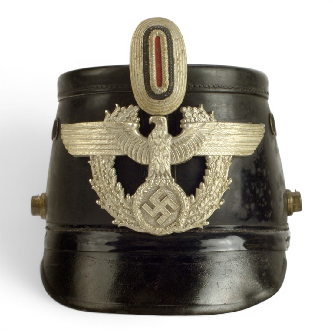 German WWII Early Pattern Metropolitan Police Shako: This German WWII early pattern Metropolitan Police shako is a formal police headgear piece from the Third Reich period. The shako form, with its tall structured body and official insignia presentation