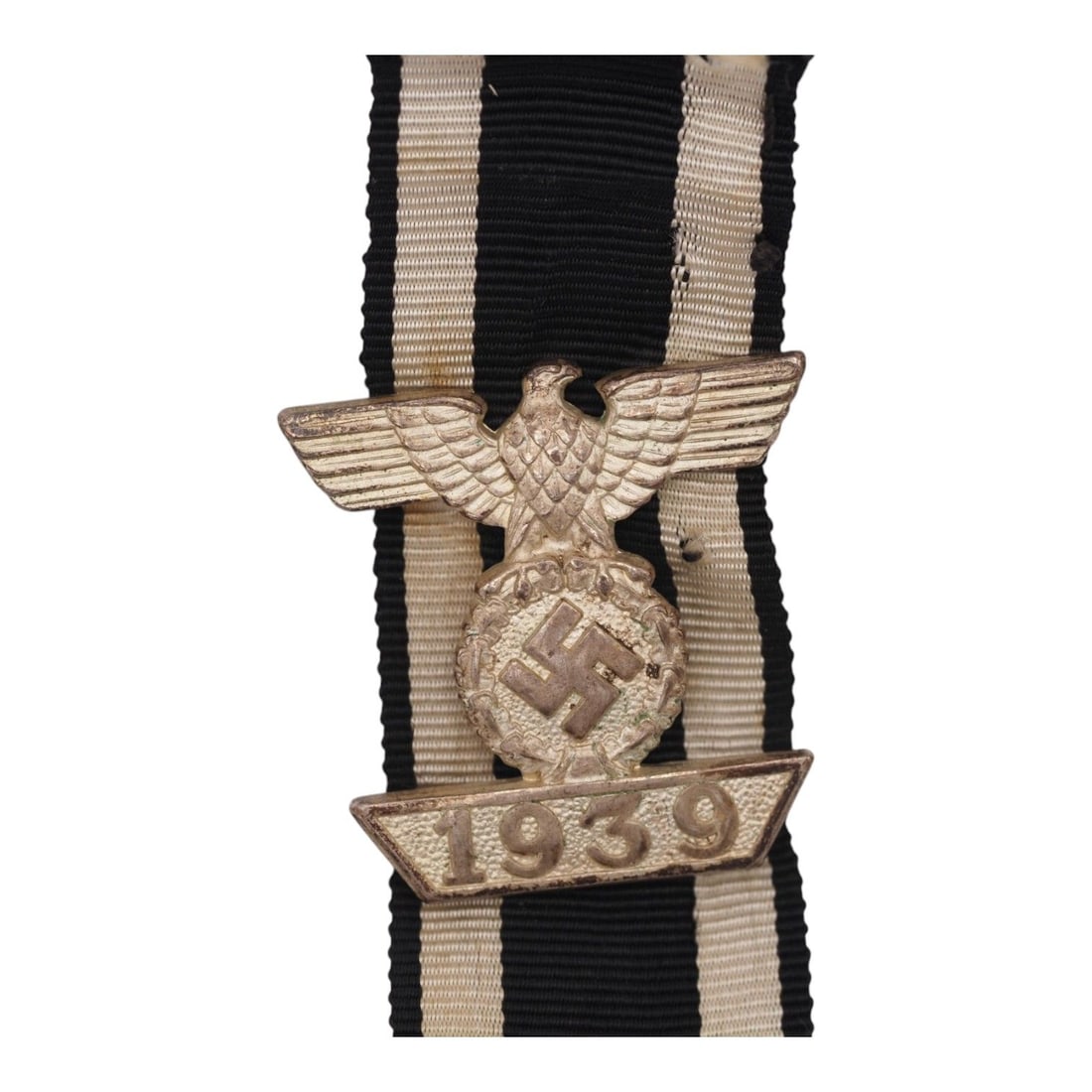 German WW2 1939 Clasp to Iron Cross 2nd Class with Original Ribbon: This classic German WWII 1939 Clasp to the Iron Cross 2nd Class, or Spange zum Eisernen Kreuz 2. Klasse, is accompanied by its ribbon and features the distinctive national eagle positioned above the d