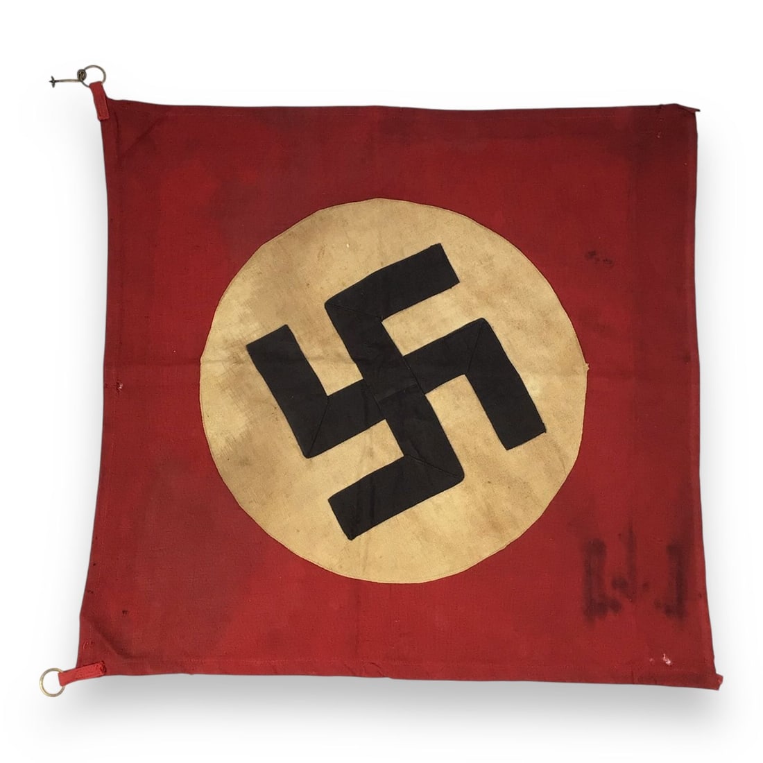 German WW2 NSDAP Swastika Insignia Flag Folded with Metal Ringlets: A WW2 German NSDAP Swastika Flag, retaining its original metal ringlets for mounting or hanging and folded for years, preserving its wartime wear. The design and wear suggests use as a military or par