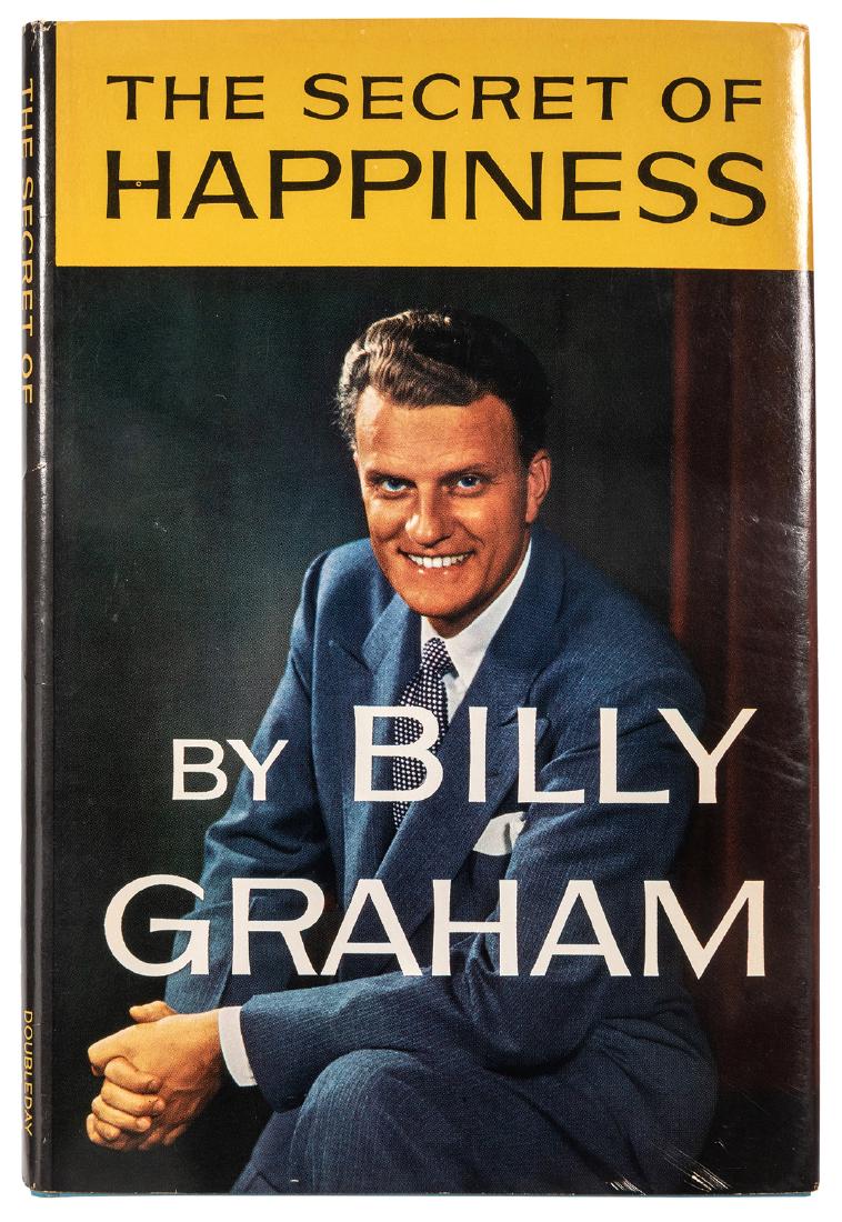 The Secret of Happiness. Signed by Billy Graham.: Graham, Billy. The Secret of Happiness. Signed by Billy Graham. Garden City: Doubleday & Co., (1955). Teal boards lettered in dark blue, unclipped color pictorial dust-jacket. Signed by Graham on the
