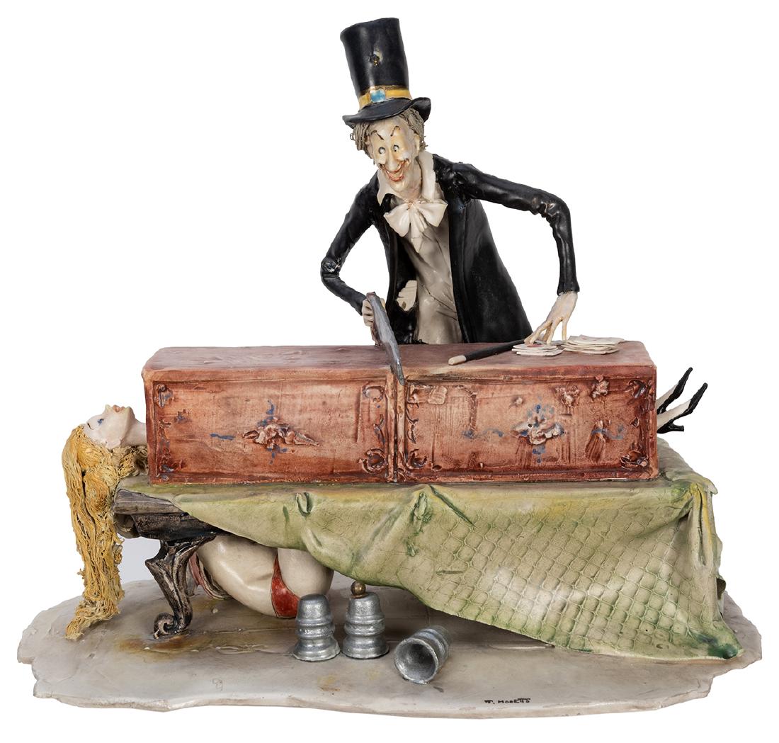 Sawing in Half Sculpture.: Moretto, Toni (Italian, 1929 – 2011). Sawing in Half Sculpture. Italy: Lo Scriccolo, ca. 1995. Caricaturish depiction of a magician with a saw in hand, his hapless assistant in a long box on a t
