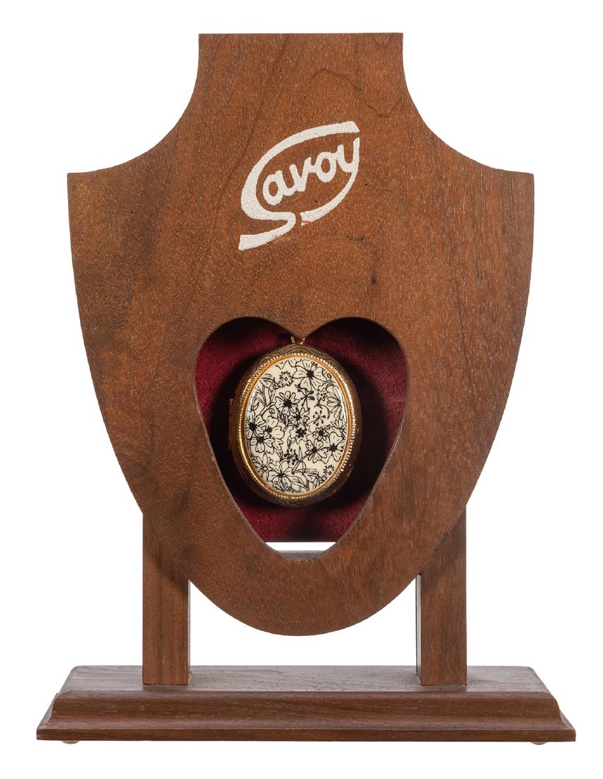 The Savoy.: The Savoy. Magikraft Studios, ca. 1993. A clever open-front box that allows the magician to visibly switch one decorated locket for a duplicate in the action of pulling the locket free from the stand.