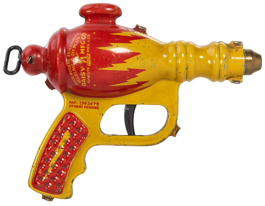 Buck Rogers Liquid Helium Water Pistol XZ-44. Plymouth,: Buck Rogers Liquid Helium Water Pistol XZ-44. Plymouth, MI: Daisy Mfg., ca. 1936. Stamped metal and painted water gun with leather sack inside to hold water. Red and yellow version. Length 7”. S
