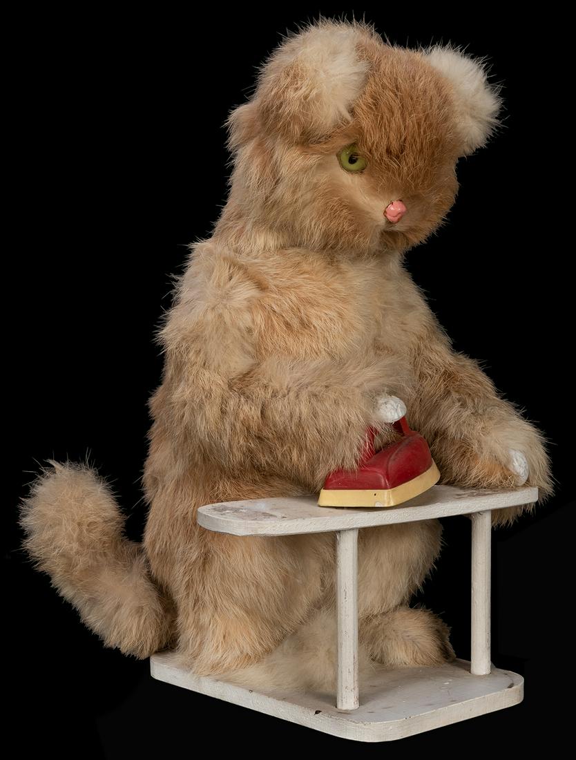 Roullet & Decamps Ironing Cat Automaton.: Roullet & Decamps Ironing Cat Automaton. Fur-covered cat figure with glass eyes standing at a wooden ironing board with plastic iron, whose head would nod and arm move side to side with iron. Electric