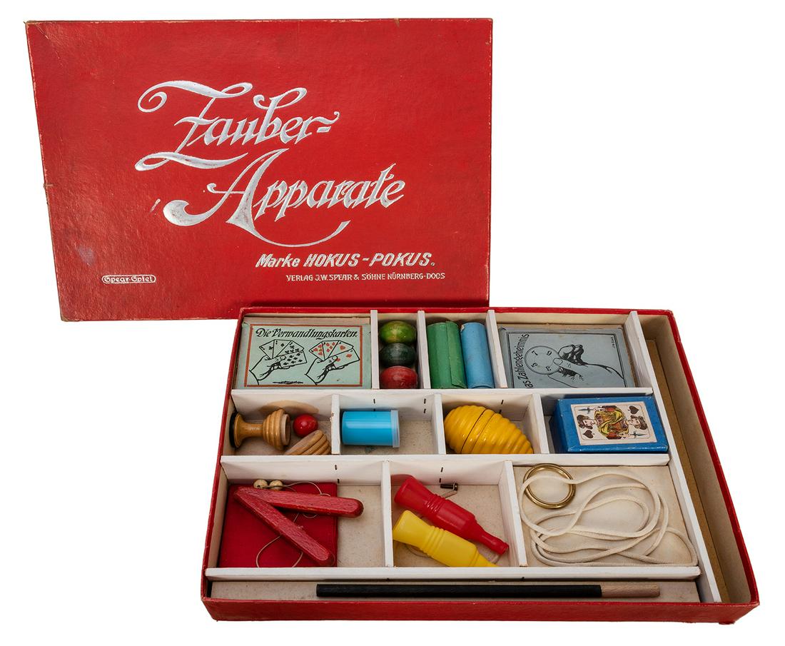 Zauber Apparate Magic Set.: Zauber Apparate Magic Set. Bavaria: J.W. Spear, 1955. Handsome vintage magic set includes wooden, cloth, paper, and plastic tricks. Silver stamped paper box. Instruction books in English and German. 1