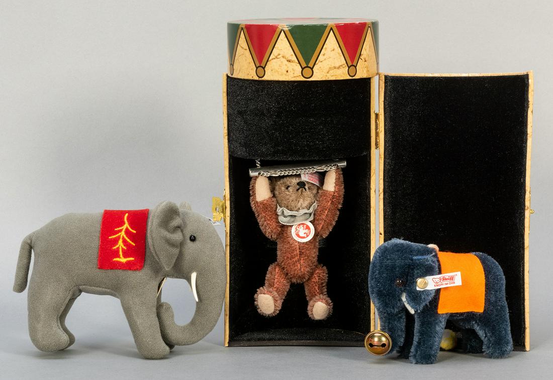 Steiff Dolly Circus Teddy and Two Elephants. Including: Steiff Dolly Circus Teddy and Two Elephants. Including Dolly Circus Teddy (669750; edition of 1,500), in original box; Steiff Jubilee Assortment elephant (400285), edition of 1,847, felt; and blue min
