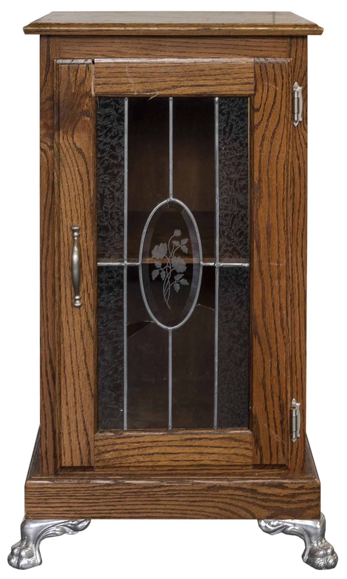 Slot Machine Stand. Oak slot machine stand with glass: Slot Machine Stand. Oak slot machine stand with glass front, central beveled glass frosted rose, claw feet, one shelf. 34 x 17 x 17”. Lacks side drawer; broken panes of glass on front, cracks to