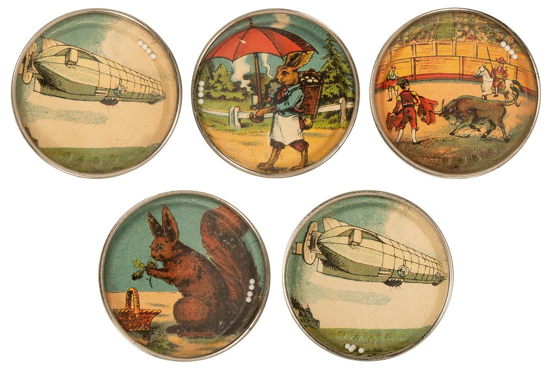 Lot of 5 Dexterity Puzzles. Early 20th century.: Lot of 5 Dexterity Puzzles. Early 20th century. Including zeppelins (2); rabbit with umbrella; squirrel (exaggerated size); and matador. Original metal casings, patterned paper backs. Diameters 2̶