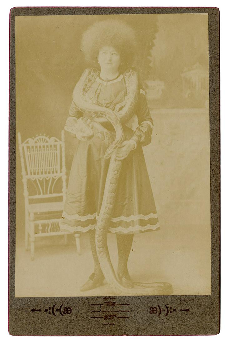 Ada Zingara Snake Charmer Cabinet Photo. 19th century.: Ada Zingara Snake Charmer Cabinet Photo. 19th century. Photograph of Zingara with a snake coiled around her neck and body, on mount imprinted with symbols. 6 ½ x 4”.