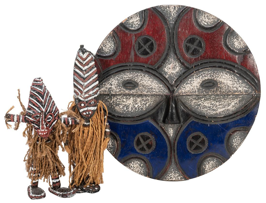 [African] Three African Ethnographic Art Items.: [African] Three African Ethnographic Art Items. Including two hand produced dolls, and a painted wooden face-like wall display (diameter 12”).