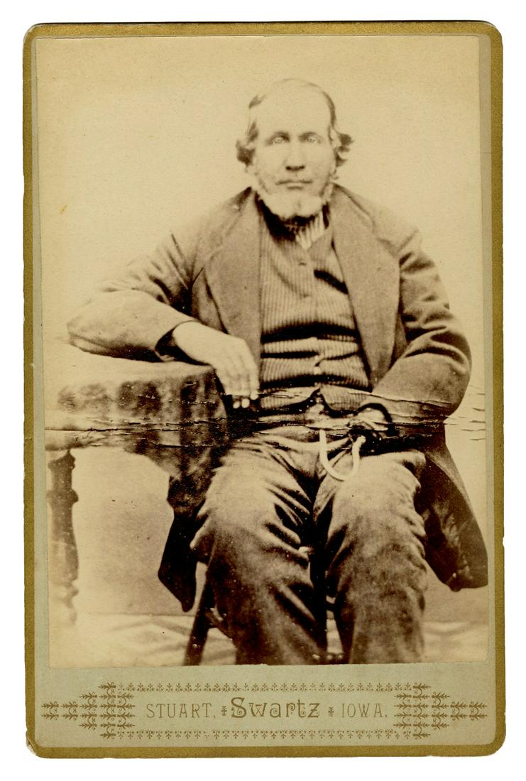 Cabinet Card of an Amputee with a Hook Hand Tool. Iowa:: Cabinet Card of an Amputee with a Hook Hand Tool. Iowa: Stuart Swartz, ca. 1870s/80s. Albumen print on original studio mount of a seated man with a hook hand tool resting on his lap. 6 ½ x 4 ¼". Lig