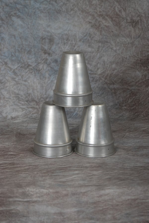 Liquid Load Cups and Balls: [Cups and Balls] Liquid Load Cups and Balls. National Magic Co., Chicago, ca. 1947. Oversized aluminum cups allow the magician to perform his regular Cups and Balls routine and at its conclusion, prod