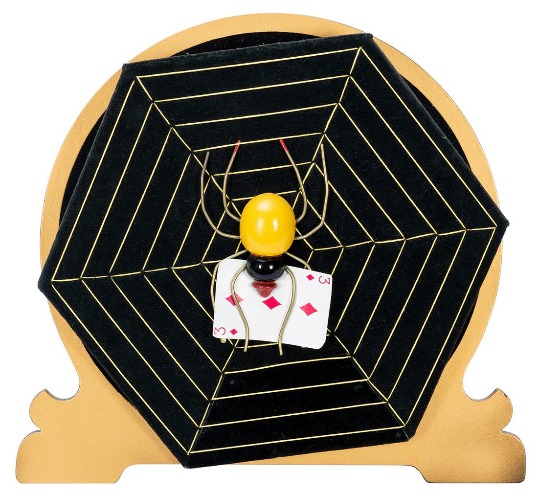 Card Spider. Azusa: Owen Magic Supreme, 1990s. As a: Card Spider. Azusa: Owen Magic Supreme, 1990s. As a spiderweb spins, a spectator’s chosen card appears in the legs of a spider at its center. On a scrollwork wooden stand. Height 13”. Hall